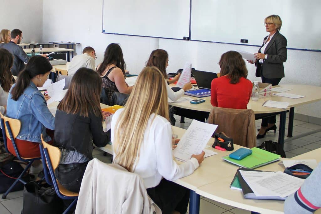 Formatrice en train de donner son cours face à sa classe d'étudiants.