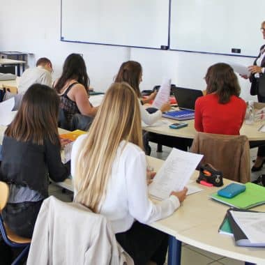 Formatrice en train de donner son cours face à sa classe d'étudiants.