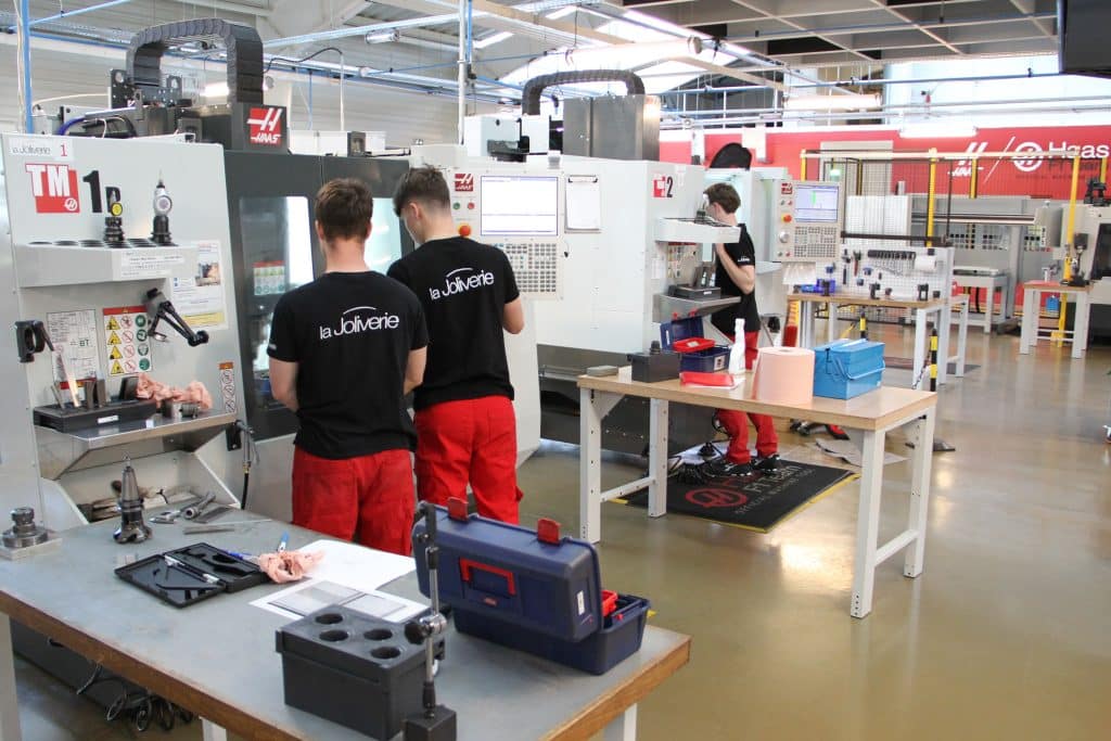 Lycéens qui travaillent sur des machines d'usinage à commande numérique dans le Gene Haas Center de la Joliverie.