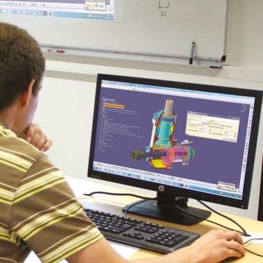 Etudiant devant son écran d'ordinateur en train d'analyser le fonctionnement d'un mécanisme industriel.