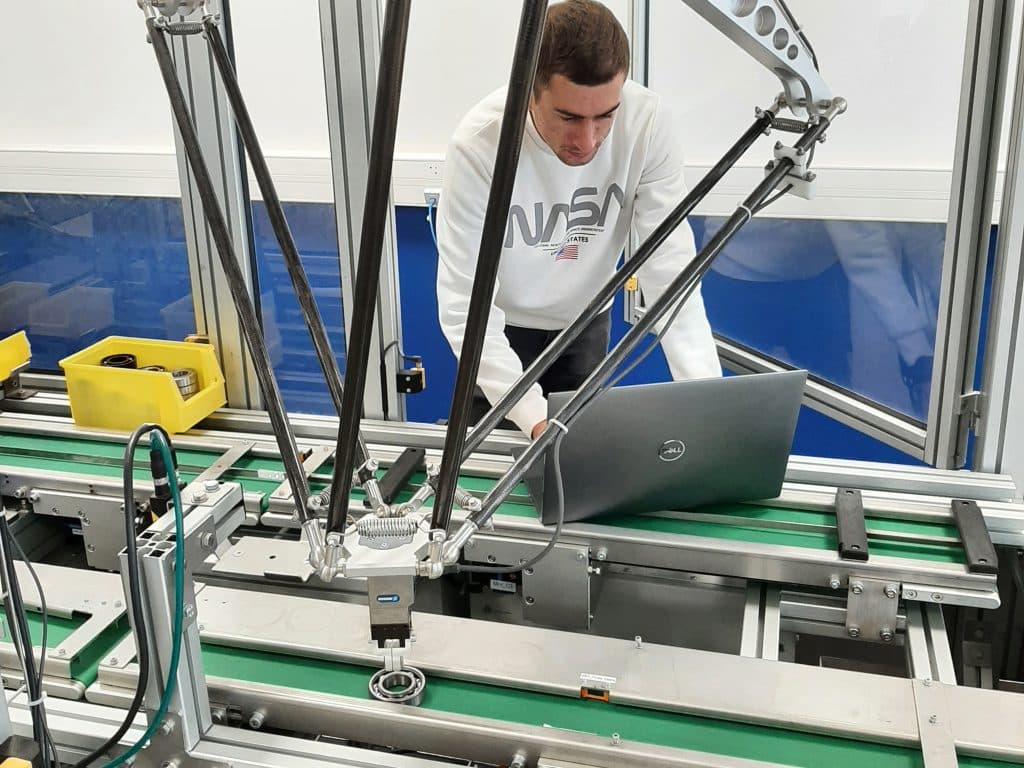 Étudiant en train de programmer un machine industrielle.