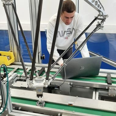 Étudiant en train de programmer un machine industrielle.
