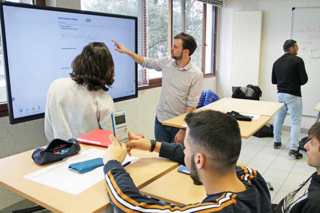 Un formateur du CFA explique son cours sur un tableau interactif dans une salle comodale.