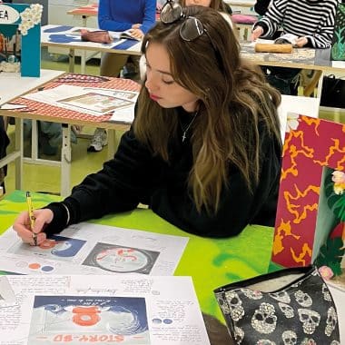 Élève en train de dessiner sur une feuille en salle de classe au Pôle des Arts Graphiques la Joliverie.