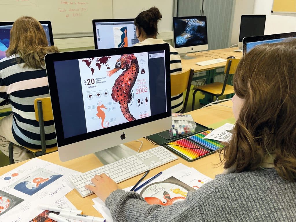 Lycéenne devant un ordinateur en train de dessiner avec un logiciel de PAO.