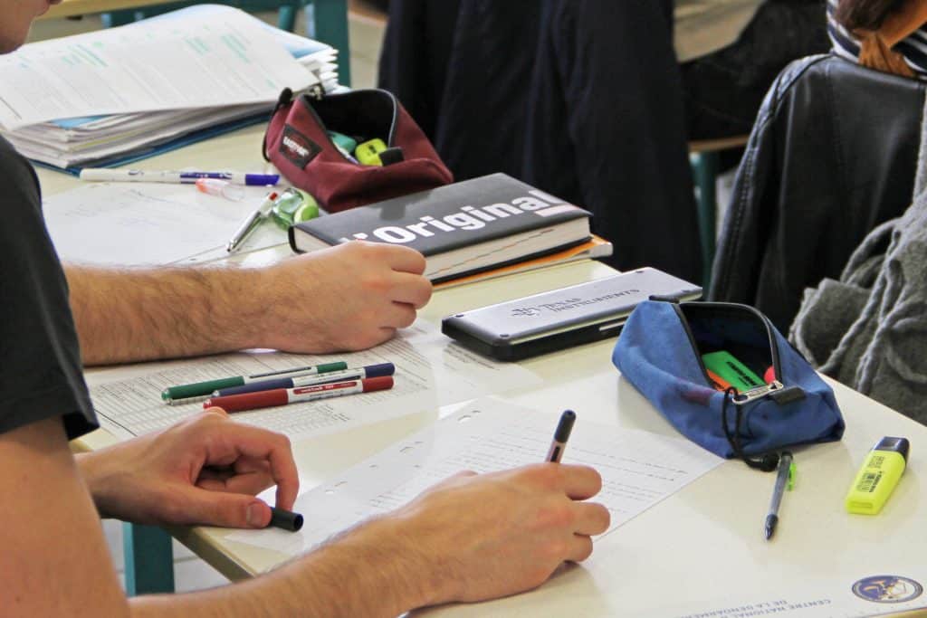 Etudiant en classe en train d'écrire sur sa feuille.