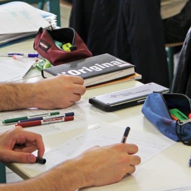 Etudiant en classe en train d'écrire sur sa feuille.