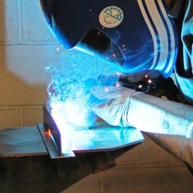 Étudiant en train de souder 2 pièces métalliques.