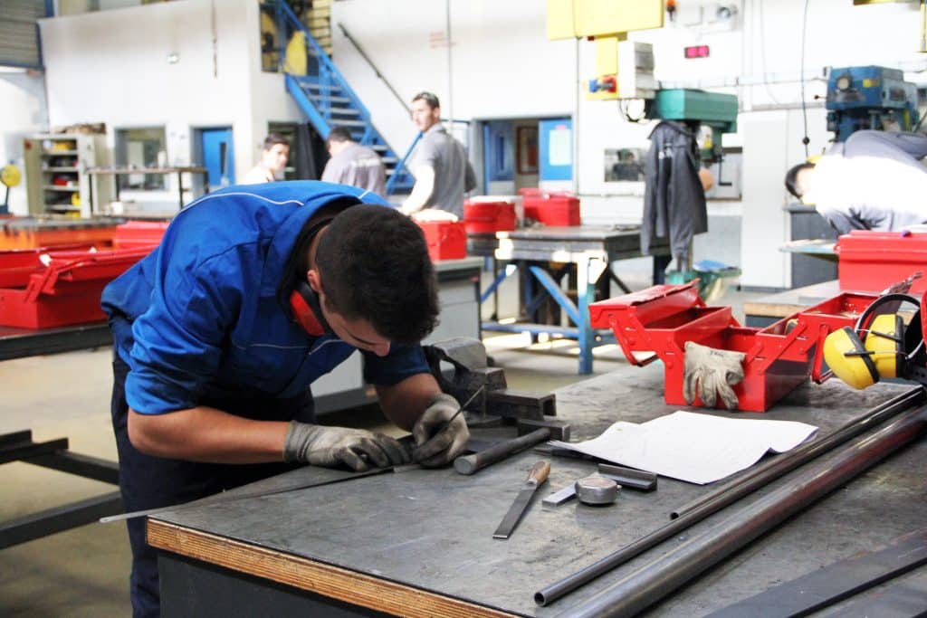 Lycéen dans un atelier en train de travailler le métal.