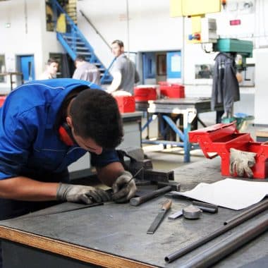 Lycéen dans un atelier en train de travailler le métal.