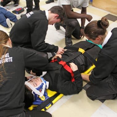 Lycéens en bac professionnel métiers de la sécurité en train d'apprendre à porter secours à une personne blessée.