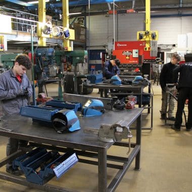 Atelier avec des élèves qui travaillent le métal.