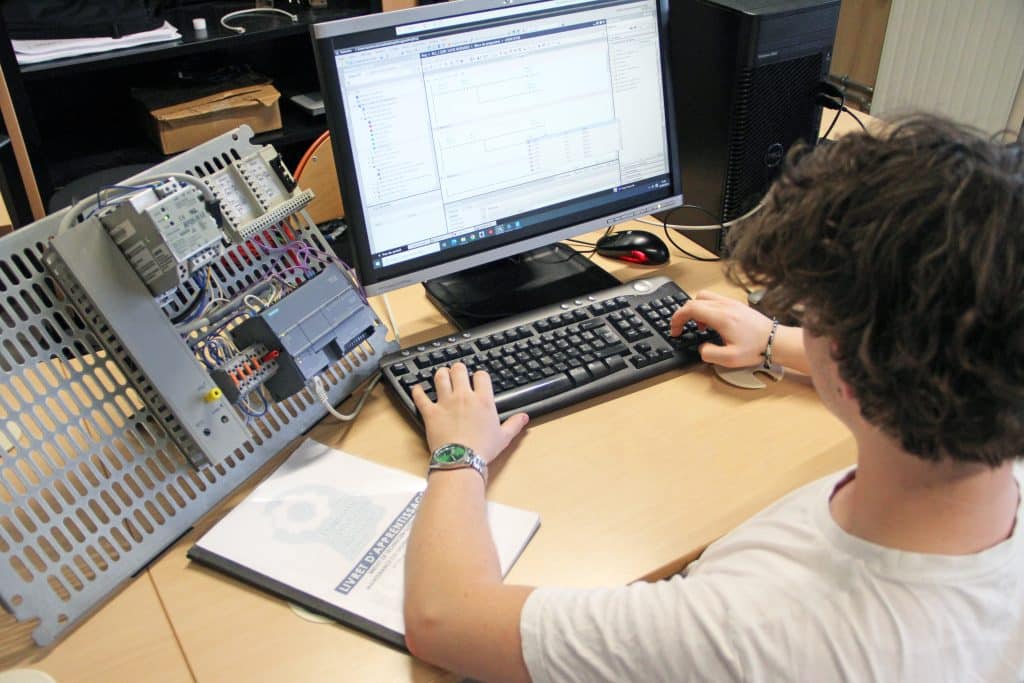 Étudiant en train de programmer un automate sur un ordinateur.