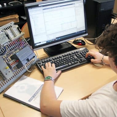 Étudiant en train de programmer un automate sur un ordinateur.