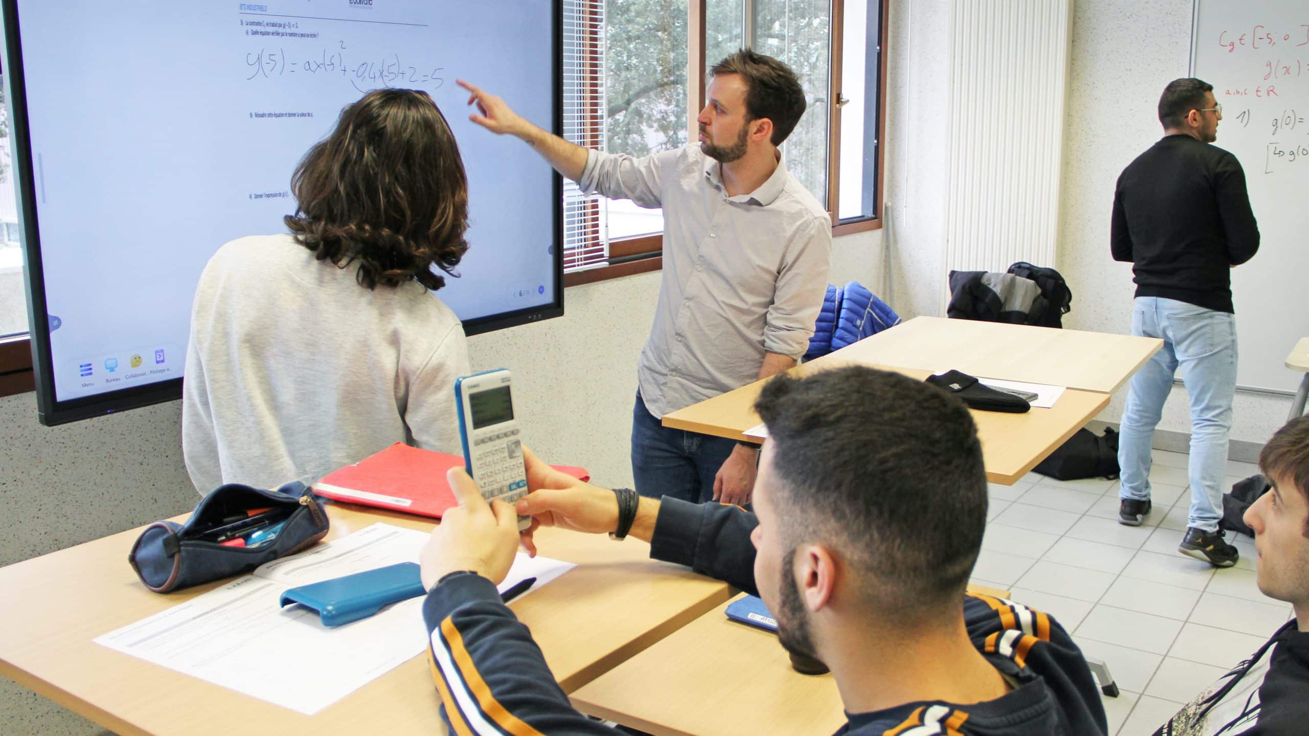 Un formateur du CFA explique son cours sur un tableau interactif dans une salle comodale.